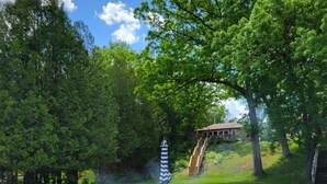 En trädgård med en eldstad, ett picknickbord och en stol.