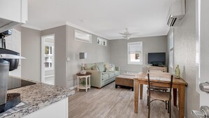 Een moderne keuken met een inbouwoven en een eethoek met een houten tafel en stoelen.