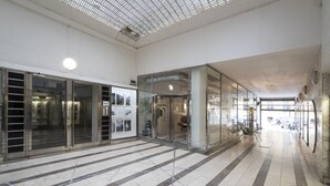 A spacious lobby with a tiled floor, large glass doors, and a ceiling with a grid pattern. - NEW TOWN - 5 ROOM 3 BALCONY APPLE (Hlavní mesto Praha)