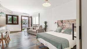 Un dormitorio moderno con una cama grande, un sofá y un comedor con mesa y sillas.