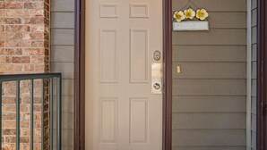 Una puerta color beige con un picaporte metálico y una pequeña placa encima.