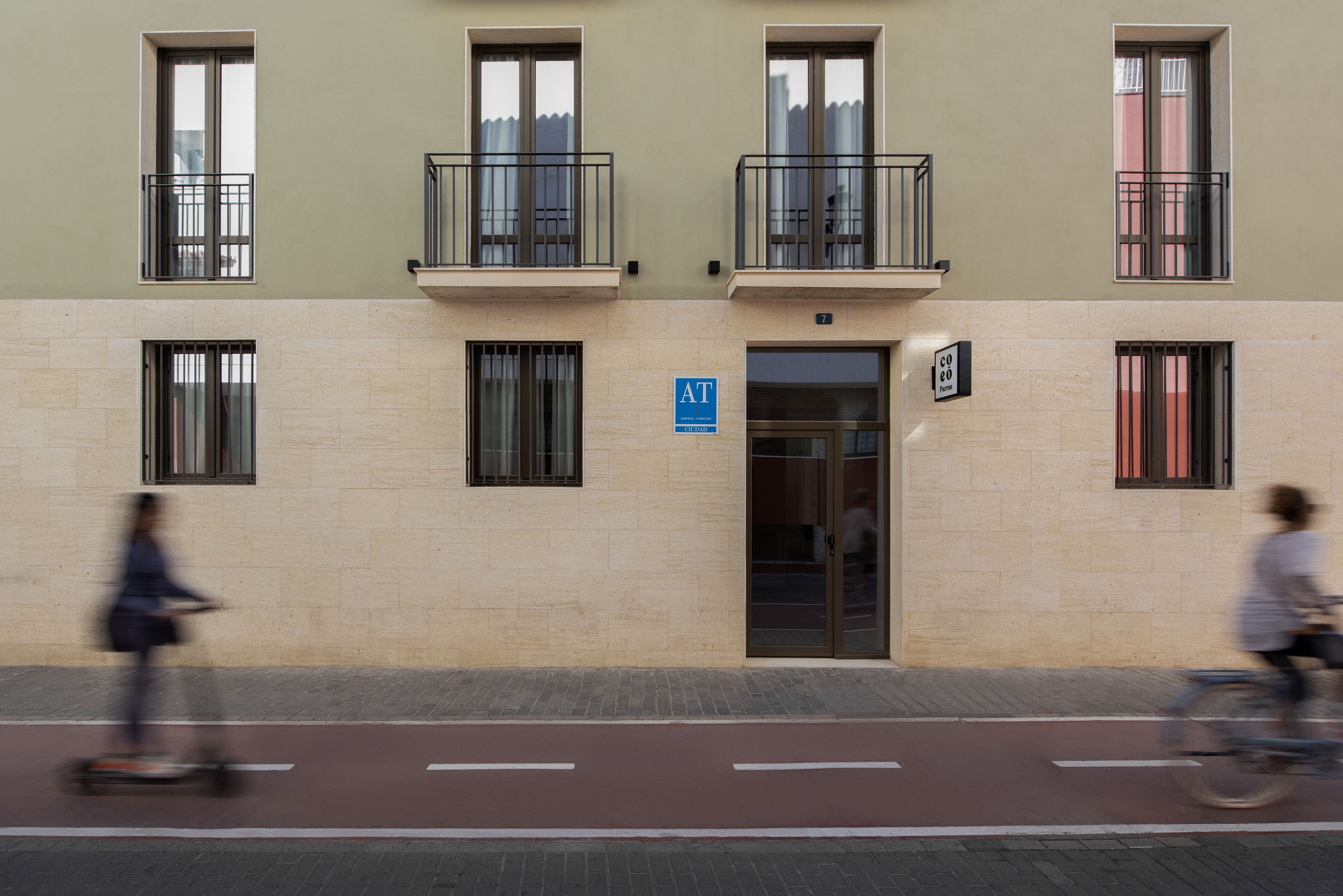 Un immeuble à la façade beige, doté de nombreuses fenêtres et de balcons.