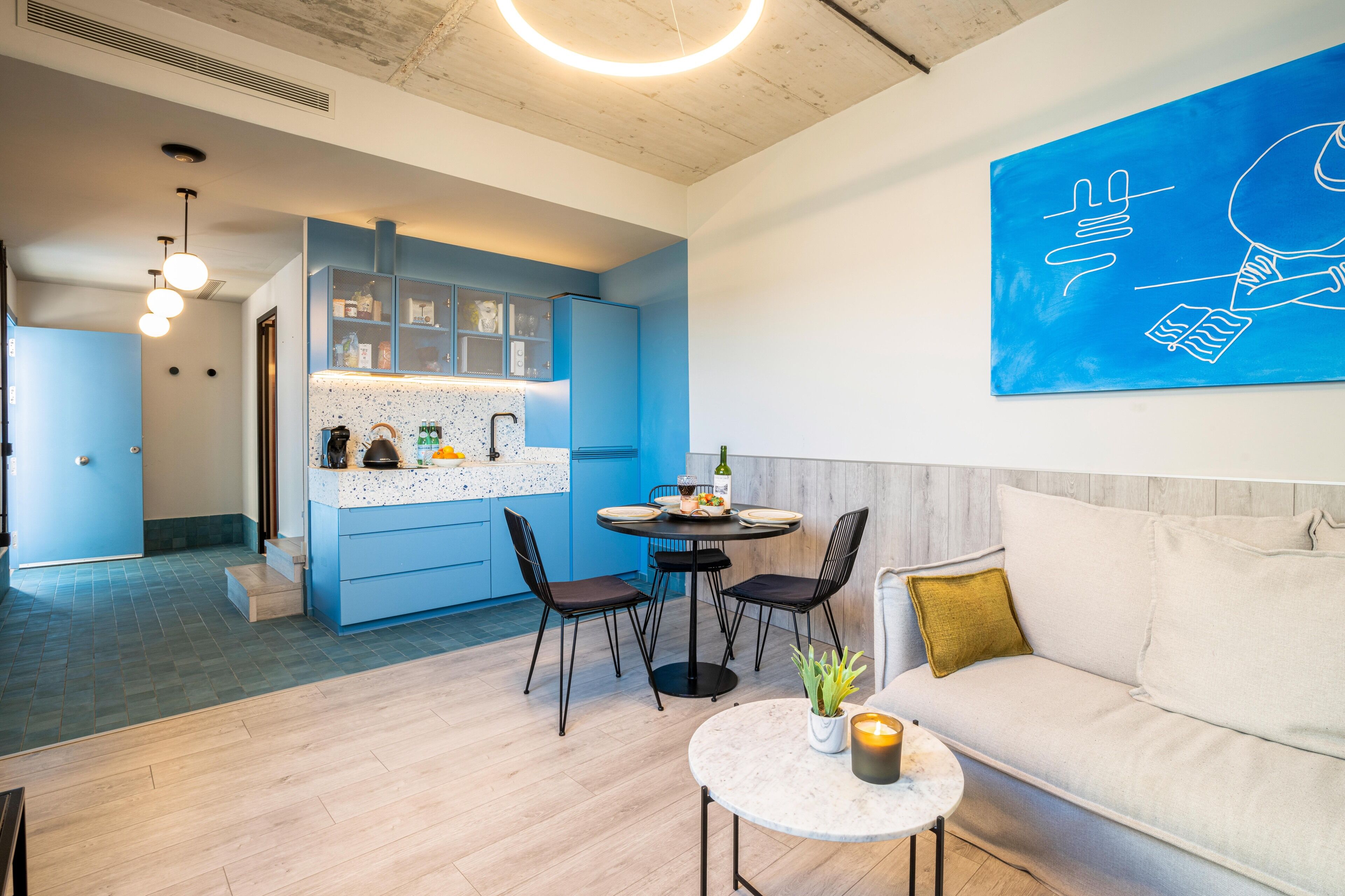 Una sala de estar moderna con sofá, una mesa de centro y un comedor con sillas y una mesa.