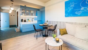 Ein modernes Wohnzimmer mit einer Couch, einem Couchtisch und einem Essbereich mit Stühlen und einem Tisch.