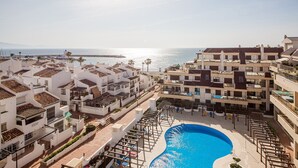 Un hôtel situé sur la côte, doté d’une piscine, de plusieurs balcons et offrant une vue sur la mer.
