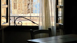 Ein Zimmer mit Blick auf ein historisches Gebäude mit einer Kuppel, einem Balkon mit aufwendigen Metallgeländern und einem Tisch mit Stühlen.