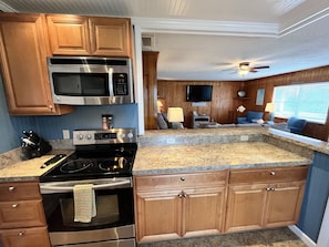 A modern kitchen with stainless steel appliances, wooden cabinets, and a granite countertop. - Cozy 3 Bedroom Cottage in Nags Head -- Extra Apt with BR + BA Available (Nags Head)