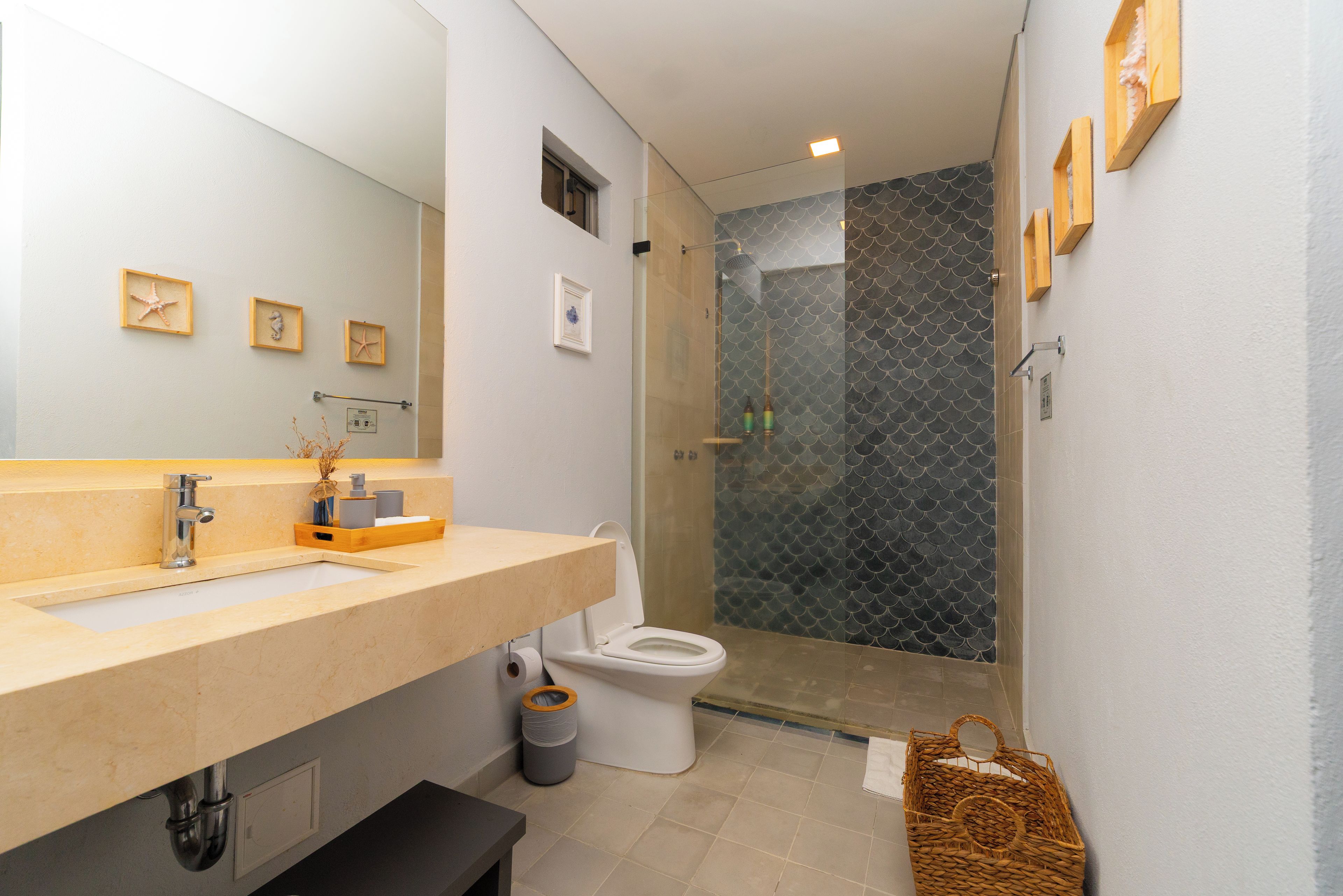A modern bathroom with a large mirror, a sink, a toilet, and a shower area.