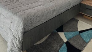 Un dormitorio con una cama grande, cabecera de madera y vistas al exterior.