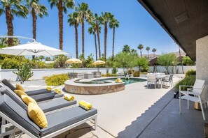 Ein Poolbereich mit Liegestühlen, Sonnenschirmen und einem Pool.