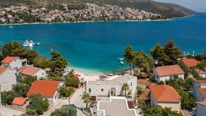 A coastal residential area with houses, a beach, and a clear view of the sea. - Luxury Villa The North Star with Pool (Okrug Gornji)