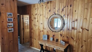 Una habitación con paneles de madera, un escritorio, un espejo y cuadros en la pared.