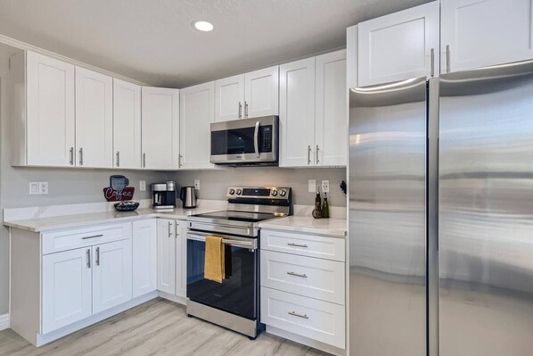 Enjoy cooking in this well-equipped kitchen with a microwave, oven, refrigerator, and coffee maker.