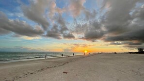 A beach with footprints leading to the water, a sunset in the background, and a clear sky. - Lovely Siesta Key house near beach w/ heated pool (Siesta Key)