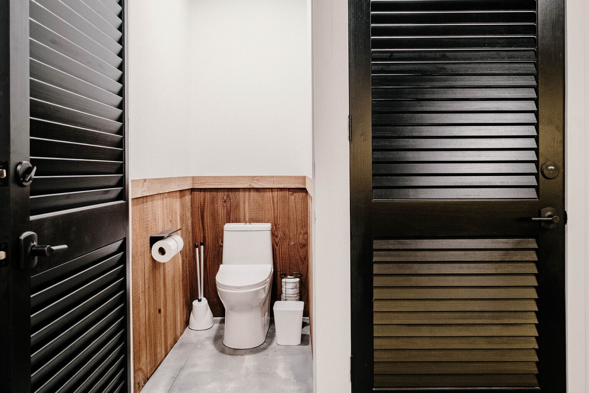 Une petite salle de bain comprenant des toilettes, un bidet et un porte-rouleau de papier toilette.