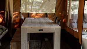 Ein Holztisch mit Schublade in einer Zelthütte.