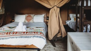 Une chambre avec un lit, une table de chevet, une lampe et une armoire en bois.