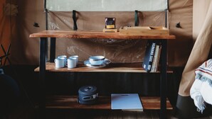 Un petit coin cuisine comprenant une table en bois, une étagère avec des ustensiles de cuisine et un livre intitulé « Les humains ».