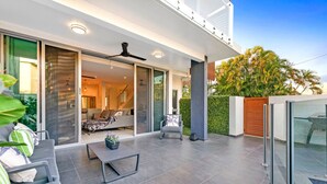 Un espacio exterior moderno con patio, asientos y vistas al interior.