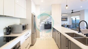 Una cocina moderna con electrodomésticos de acero inoxidable, microondas integrado y una isla grande con fregadero.
