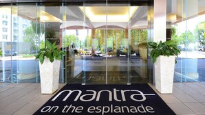 A hotel entrance with a glass facade, a black mat with "mantra on the esplanade" text, and potted plants on either side. - Coastal Splendor: Seaview ~ Pool ~ Balcony Dining (Darwin City)