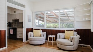 Una habitación con dos sillones, una mesita y un ventanal con vistas a zonas verdes.