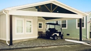 A covered garage with a golf cart parked inside. - Family Friendly Venture Out Getaway  (Panama City Beach)