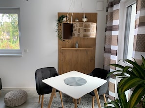 Relax in a serene space with a view of lush greenery, featuring a stylish table and comfortable seating.