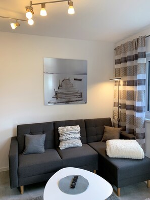 Relax in a stylish living room with a sofa, abstract art, and a floor lamp.