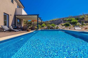 A clear blue swimming pool with lounge chairs and a covered patio area. - Villa BELLA VISTA with sea view (Dobrinj)