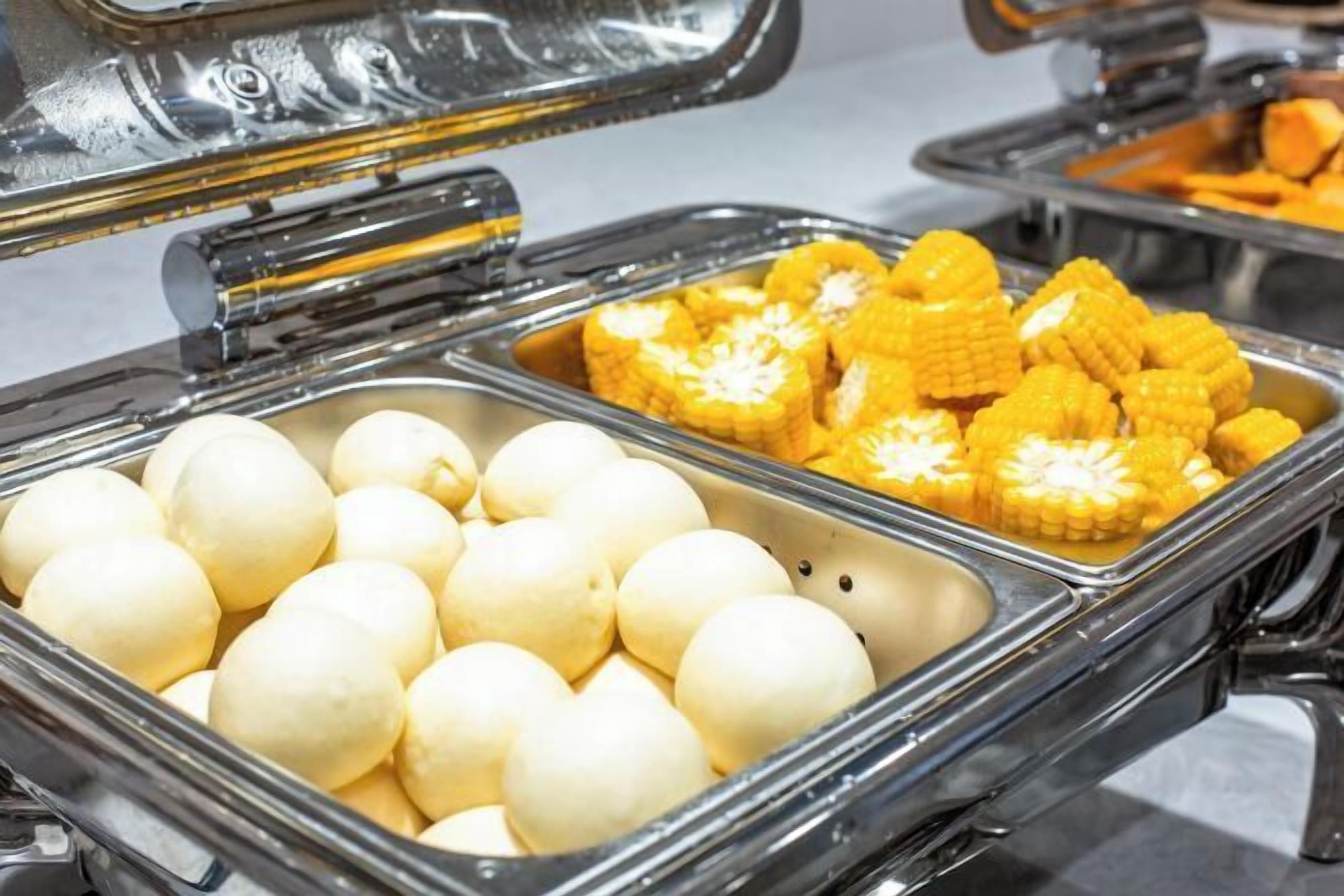 A buffet with two sections: one with boiled eggs and another with corn on the cob.