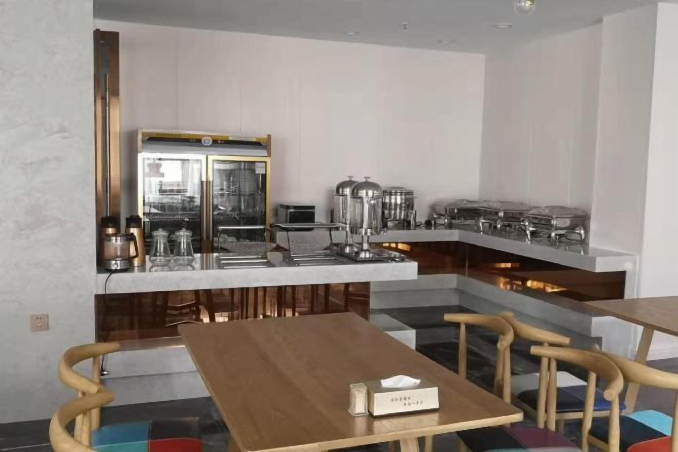 A modern kitchen with a bar area, equipped with appliances and a coffee machine.