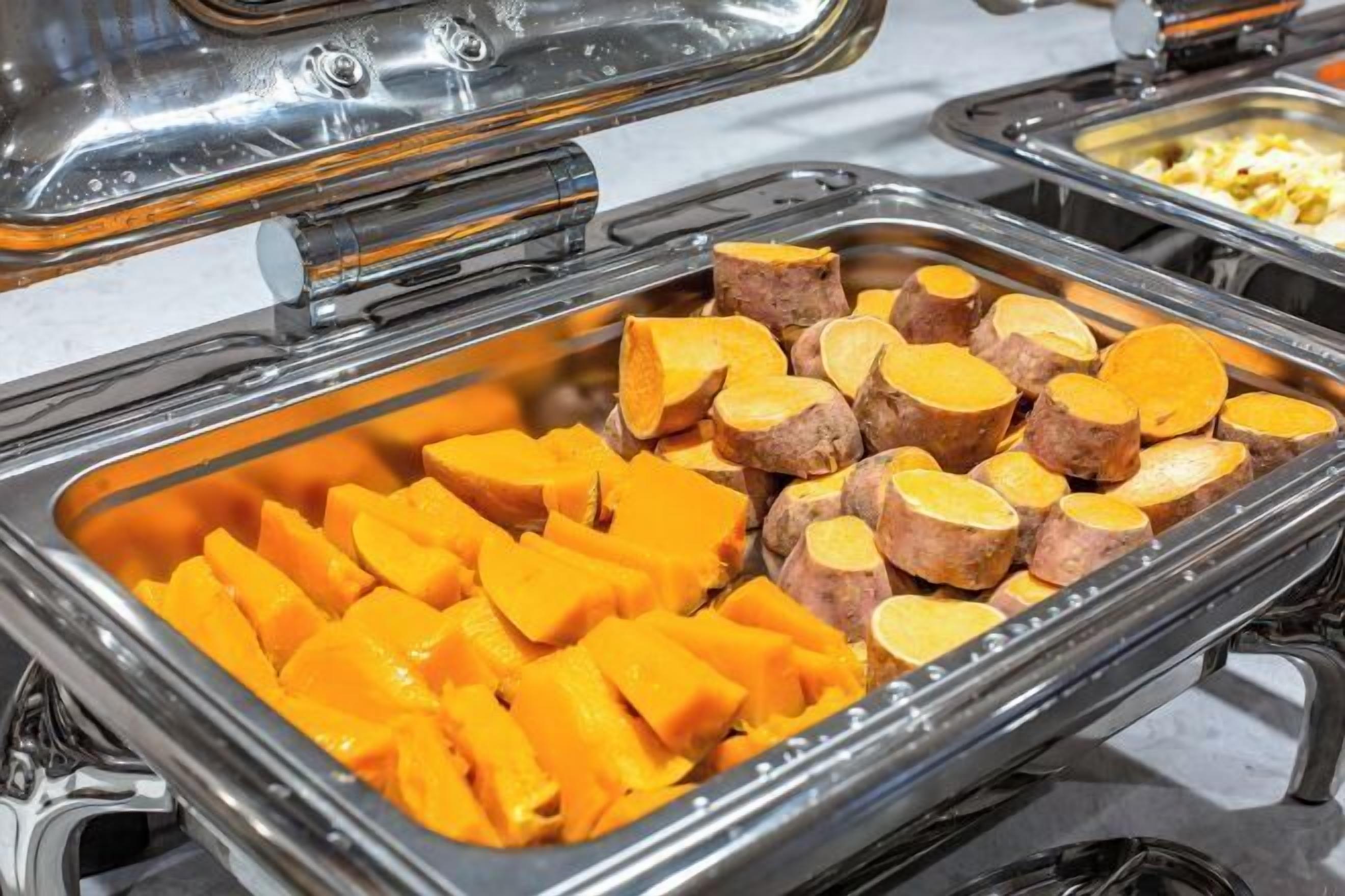 Un bufé con diversos alimentos, incluyendo batatas en rodajas y otros platos.