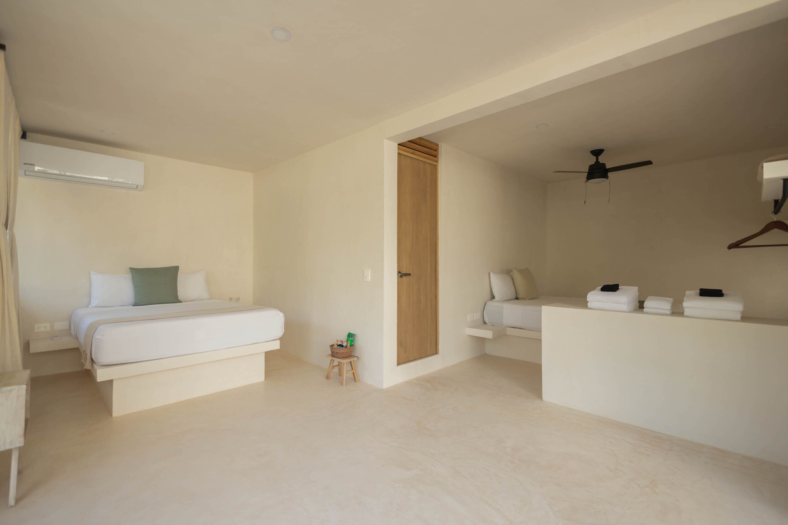A modern bedroom with a bed, a small table, a hanging light, and a ceiling fan.