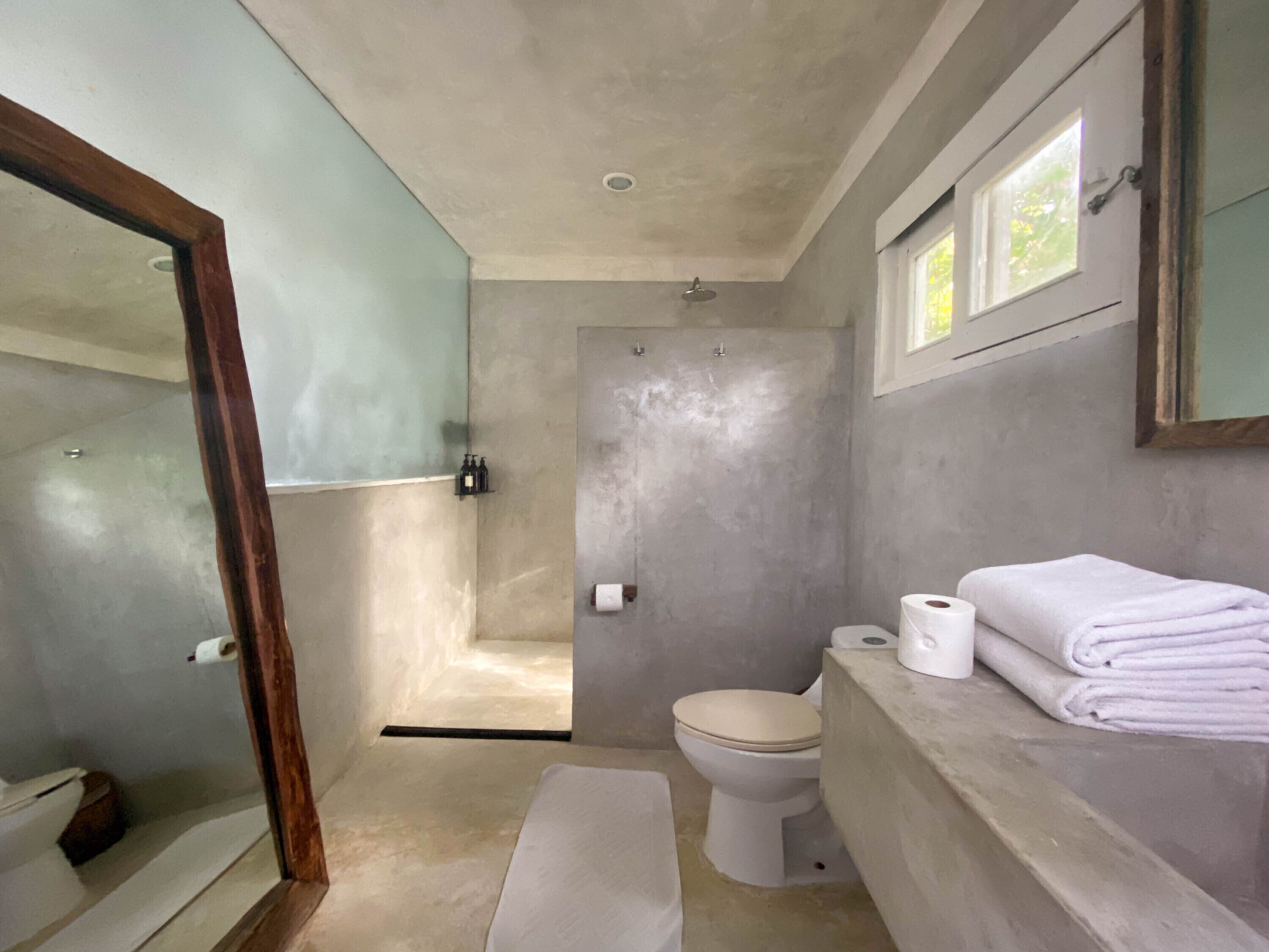 A bathroom with a shower, toilet, and sink.