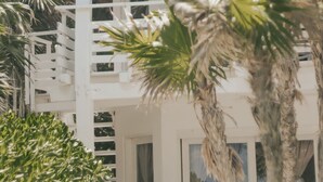 A white building with a thatched roof, surrounded by palm trees. - Tuup Tulum (Tulum)