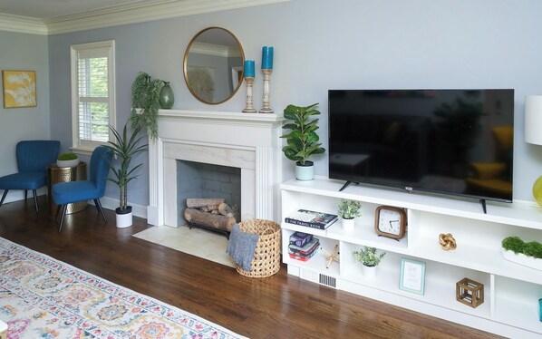 A living room with a fireplace, a television, and a bookshelf.