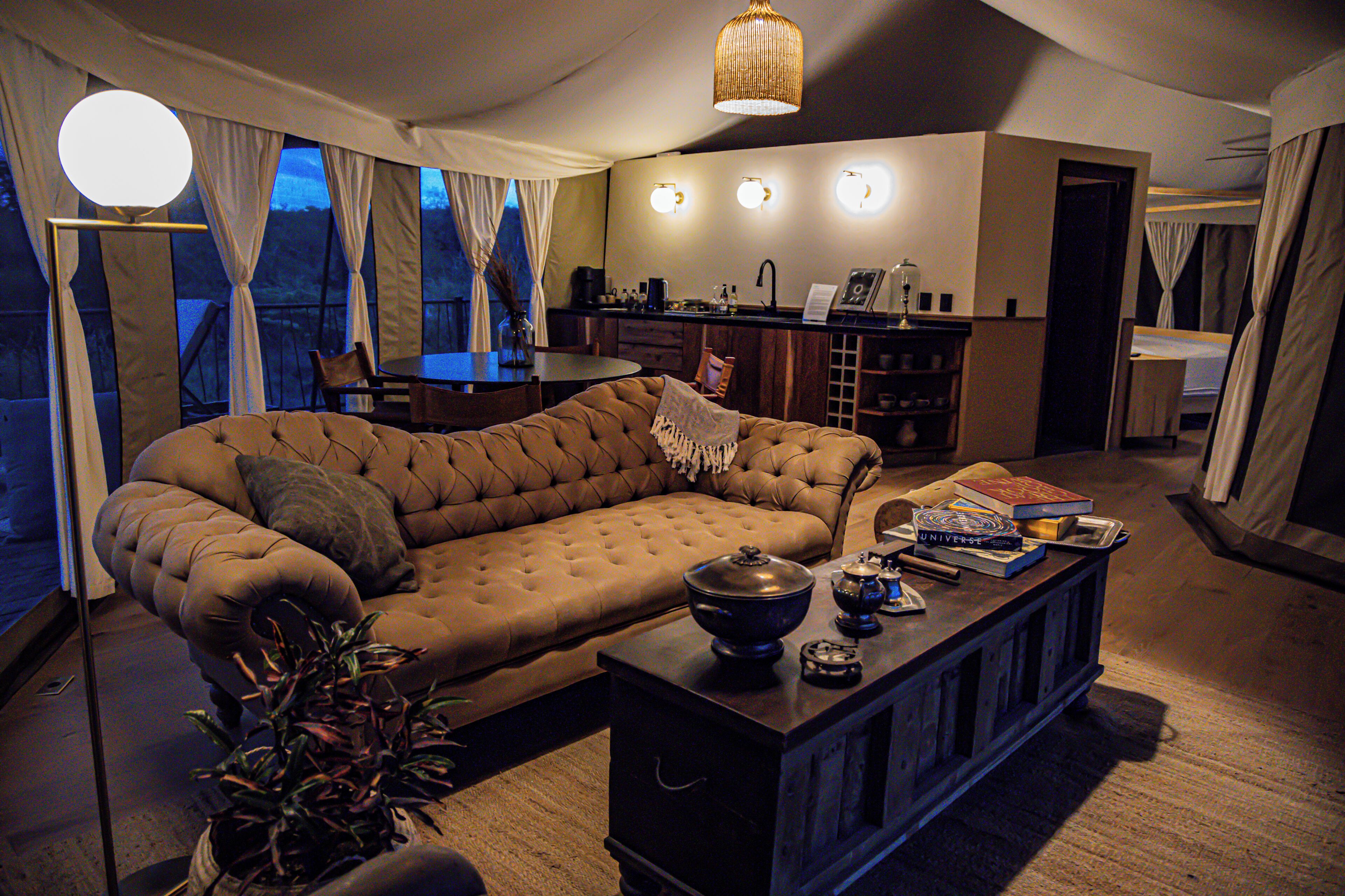 A living room with a sofa, a coffee table, and a dining area with a table and chairs.