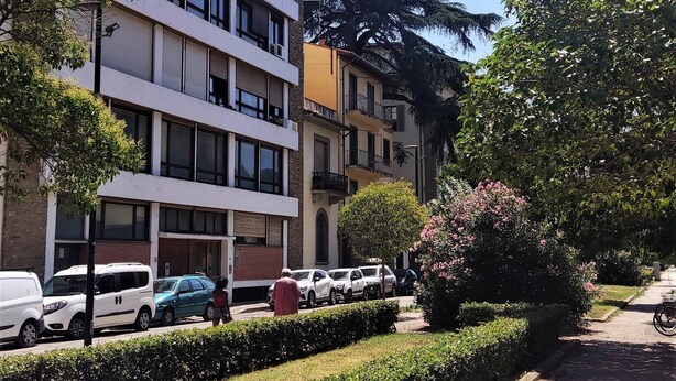 A multi-story building with a modern design, featuring balconies and large windows. - Small and cozy studio apartment in the center of Florence (FIRENZE)