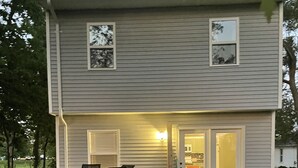 A two-story house with a patio area featuring outdoor furniture. - The Capitol House-East Village/Downtown, King Bed (Des Moines)