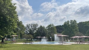 A park with a fountain, picnic tables, and covered seating areas. - The Capitol House-East Village/Downtown, King Bed (Des Moines)
