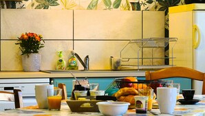Une table de petit-déjeuner avec divers aliments, un vase rempli de fleurs et des appareils de cuisine.