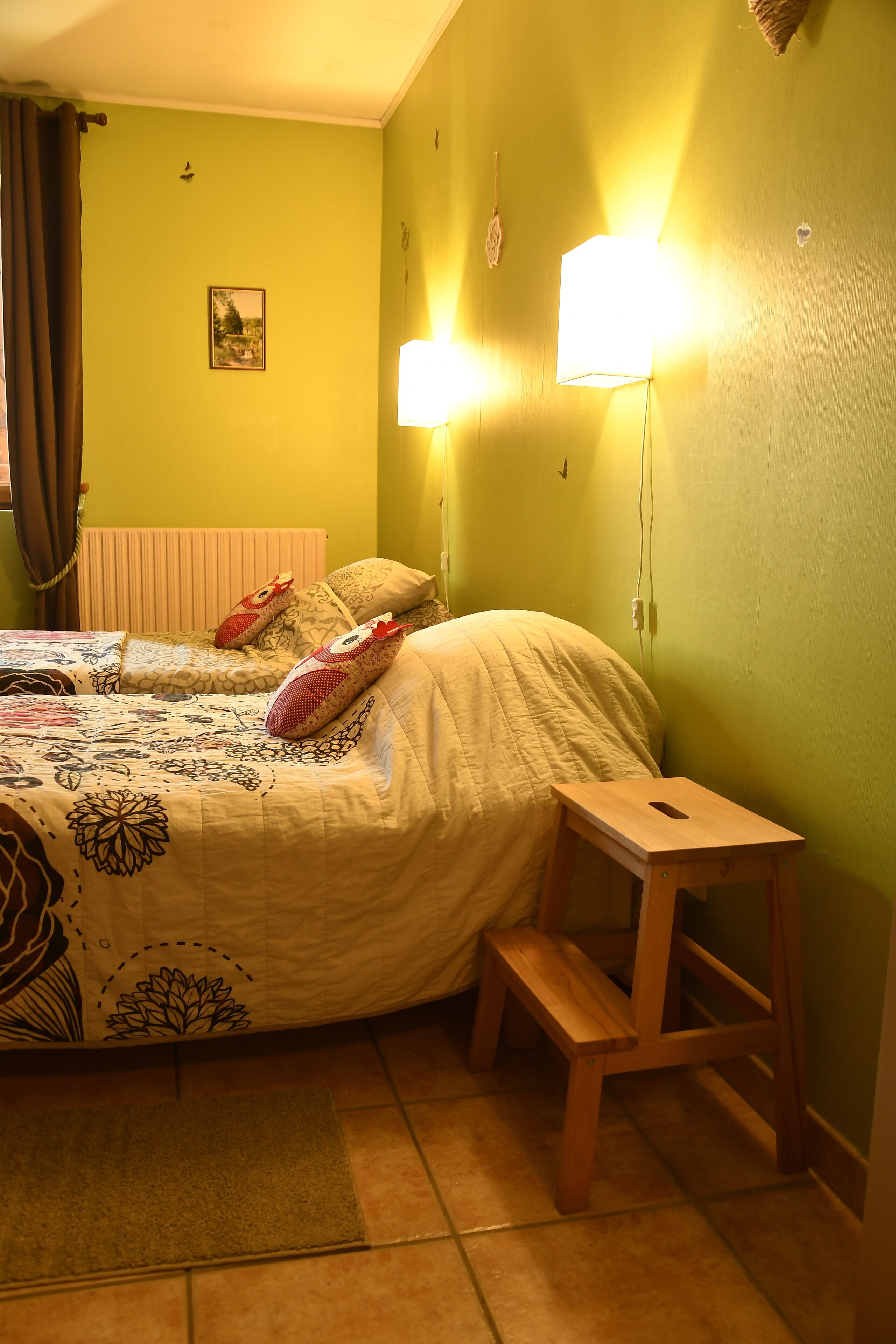 Ein Schlafzimmer mit Bett, Nachttisch und einer Wandleuchte.