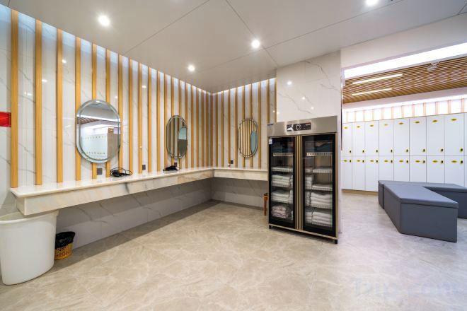 Un baño moderno con tocador, espejos, perchero y una zona de estar.