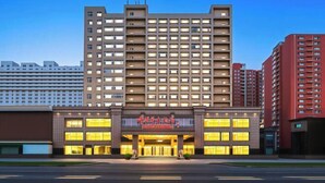 A multi-story hotel with a prominent entrance, large windows, and a modern architectural design.