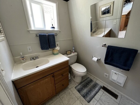 Een badkamer met een wastafel, toilet en spiegel.