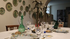A dining table set with plates, glasses, and cutlery, surrounded by decorative plates on the wall. - Charming Bed and Breakfast in Castiglione di Sicilia (Castiglione di Sicilia)