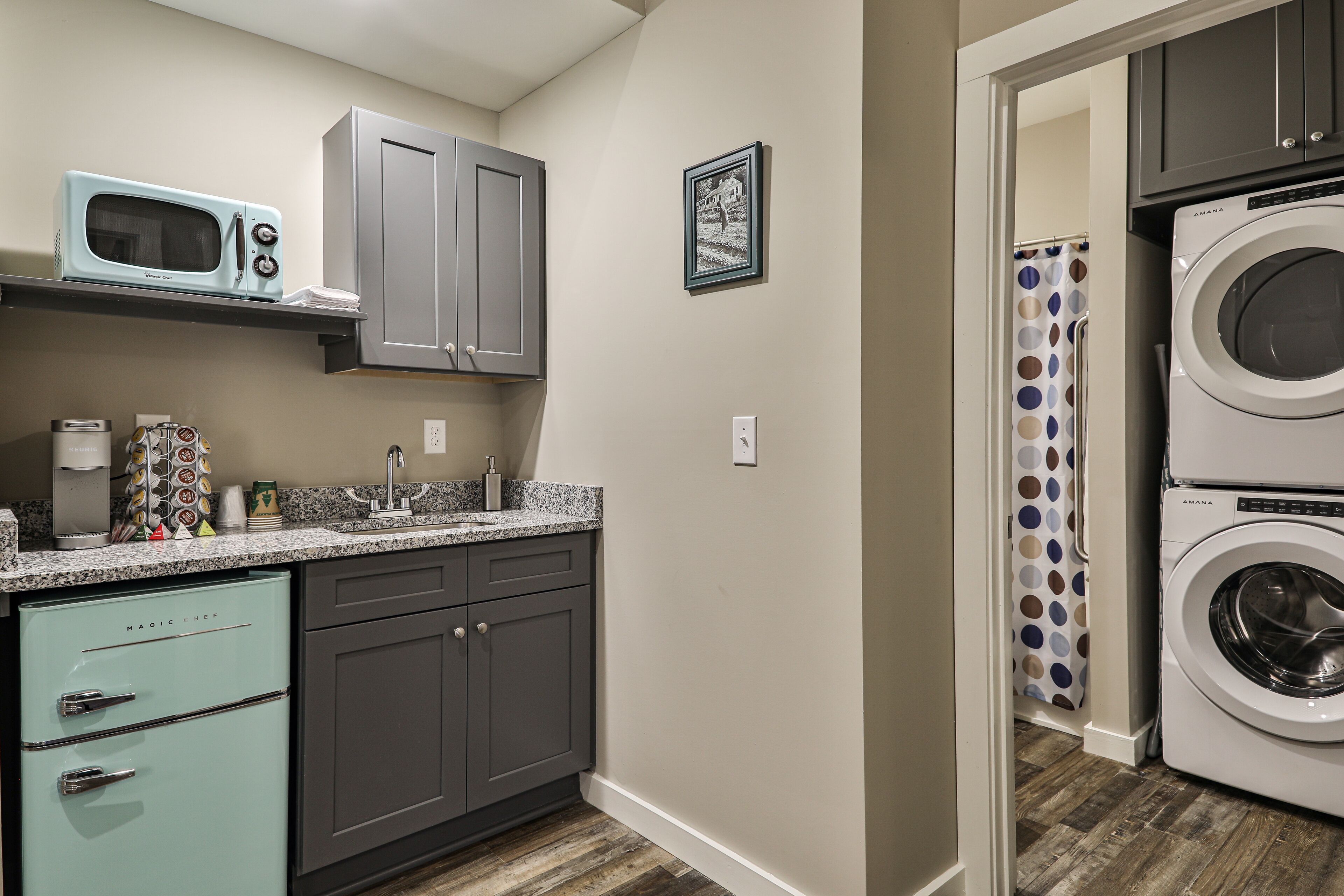 A compact kitchen with a microwave, a washing machine, and a sink.