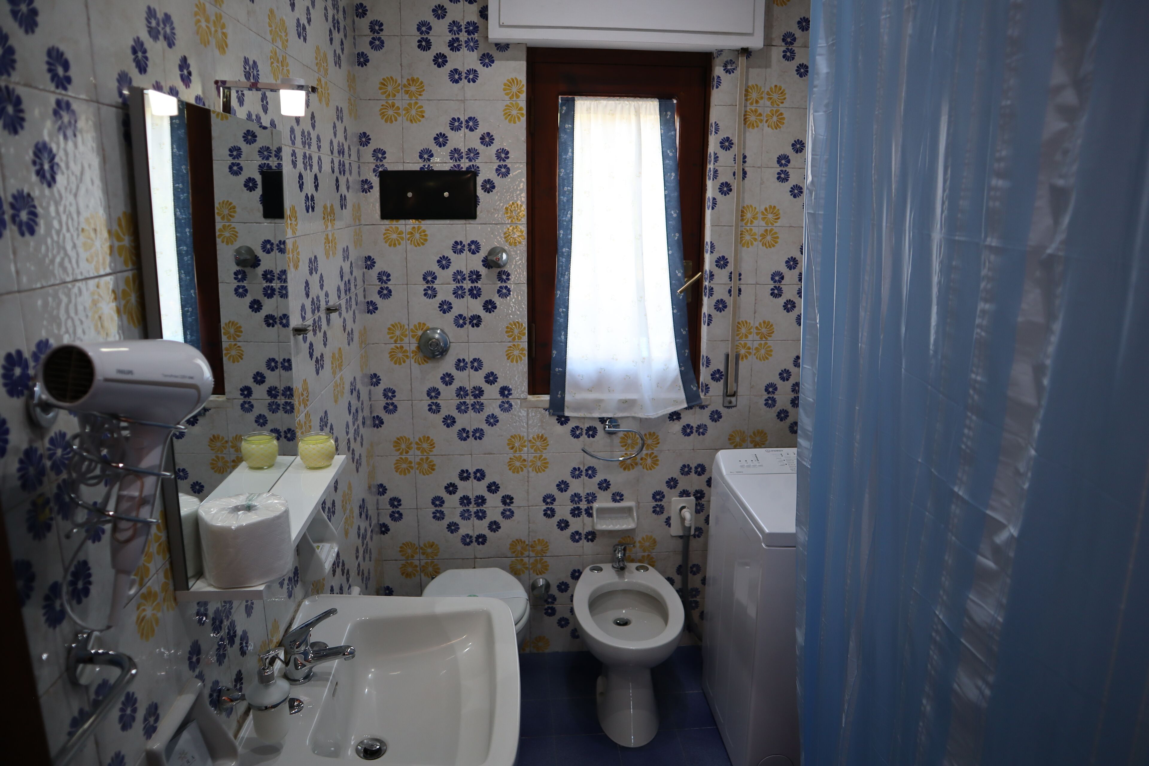 Une salle de bain équipée de toilettes, d’un bidet, d’un lavabo et d’un miroir.