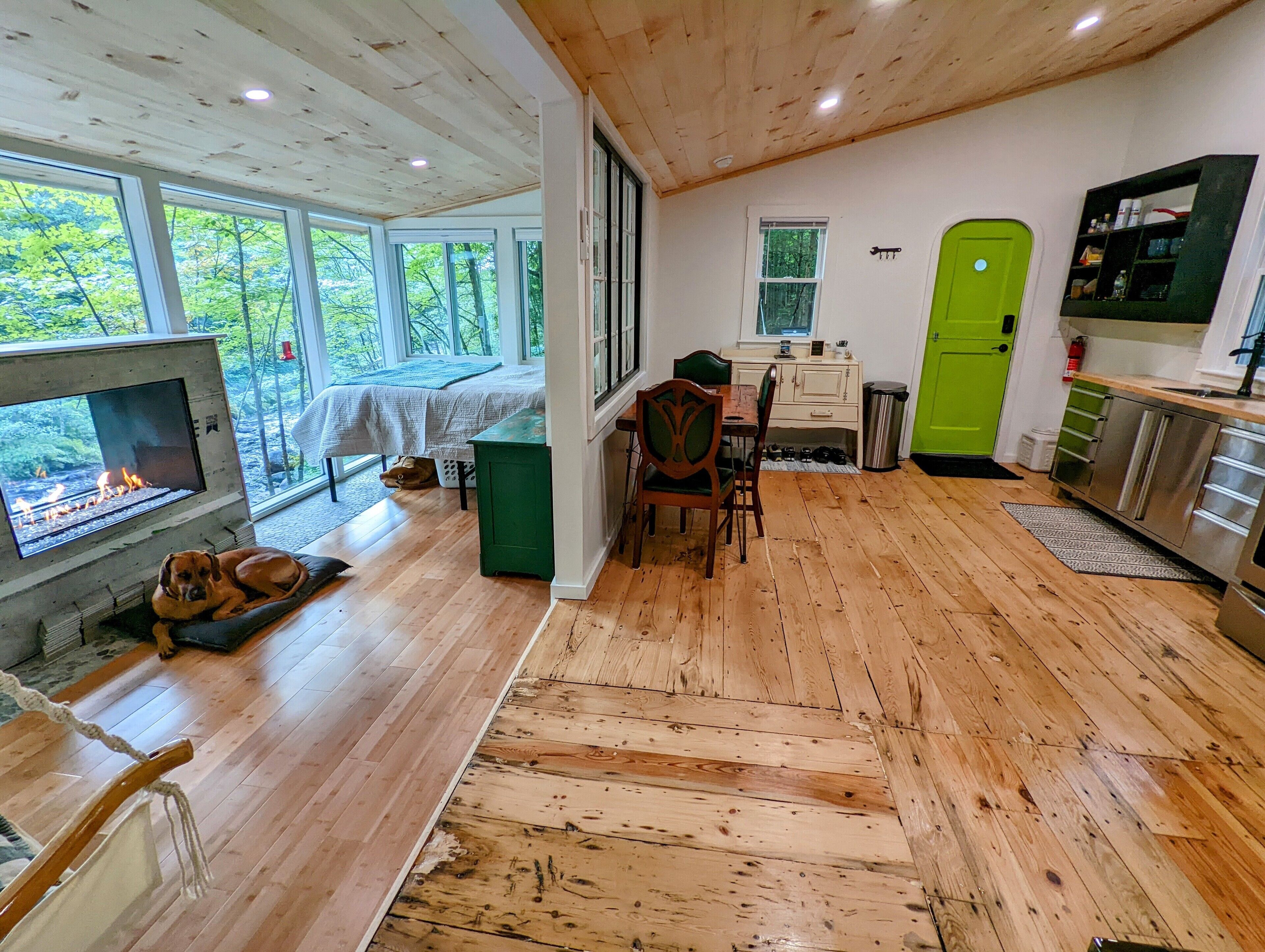 Interior acogedor de una cabaña con chimenea, pisos de madera y un comedor.